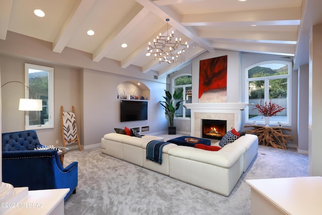 carpeted living room with a chandelier, vaulted ceiling with beams, and a tiled fireplace