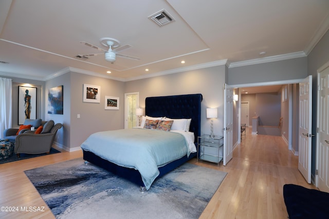 bedroom with ceiling fan, light wood-type flooring, and ornamental molding