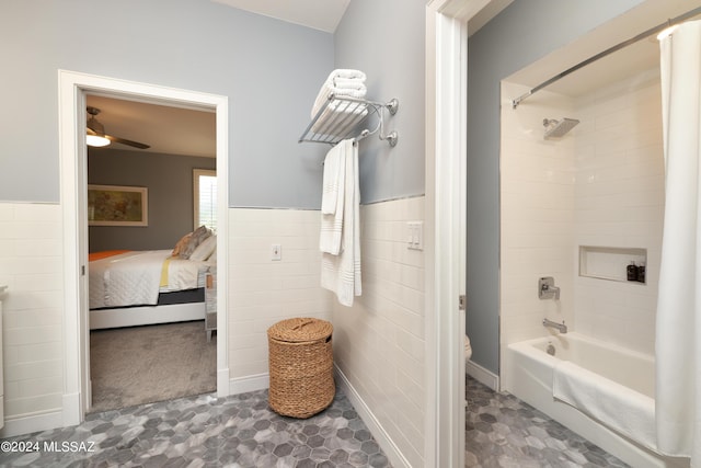 bathroom featuring shower / bathtub combination with curtain, toilet, tile walls, and ceiling fan