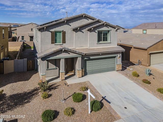 traditional-style house featuring concrete driveway, an attached garage, a tiled roof, and stucco siding