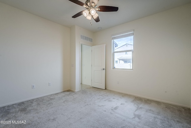 unfurnished bedroom with baseboards, visible vents, ceiling fan, and light colored carpet