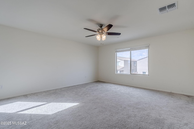 spare room with baseboards, carpet, visible vents, and a ceiling fan