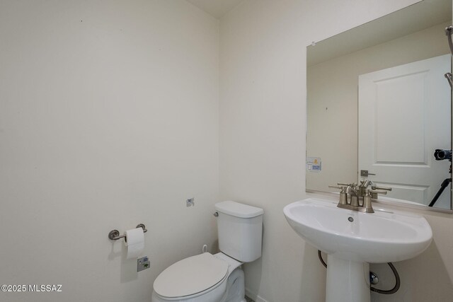 full bathroom with a spacious closet, double vanity, a stall shower, and a sink