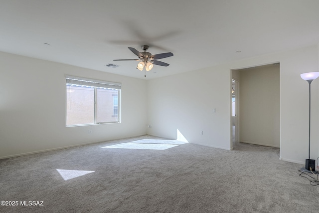 carpeted spare room featuring ceiling fan and visible vents