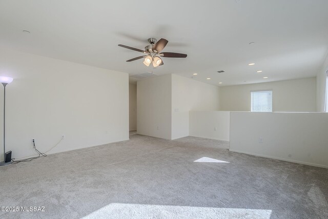 spare room featuring carpet floors, visible vents, and a ceiling fan