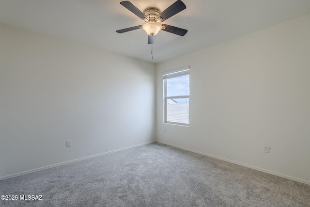 carpeted empty room featuring ceiling fan and baseboards