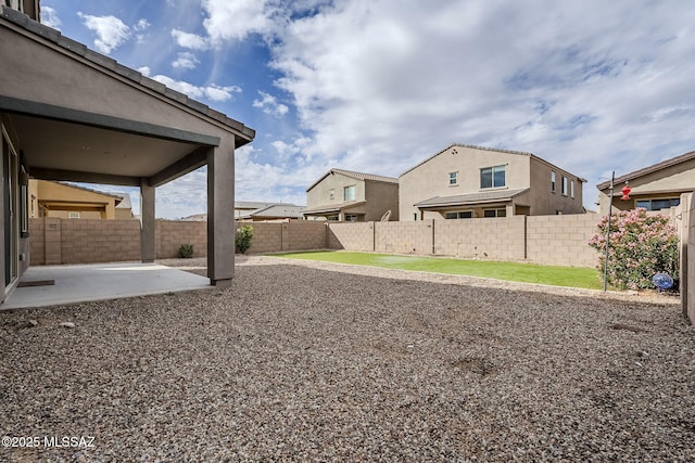 view of yard with a patio area, a fenced backyard, and a residential view