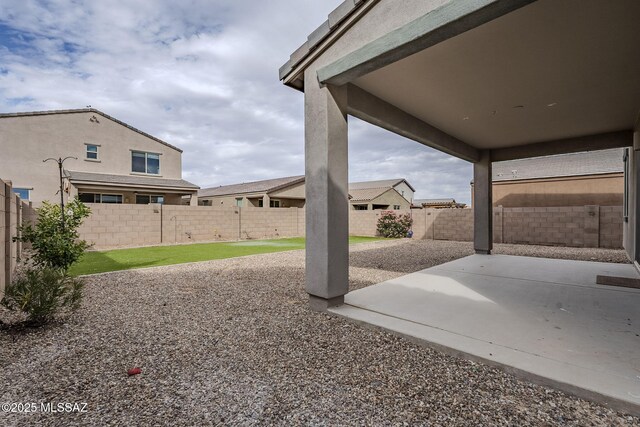 back of house featuring stucco siding, a fenced backyard, a lawn, and a patio