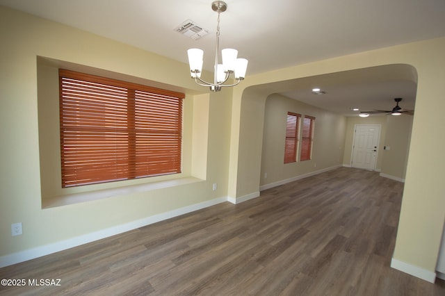 empty room featuring wood-type flooring and ceiling fan with notable chandelier