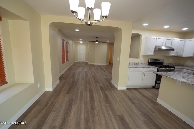 kitchen with ceiling fan with notable chandelier, decorative light fixtures, white cabinetry, dark hardwood / wood-style floors, and stainless steel range with gas cooktop