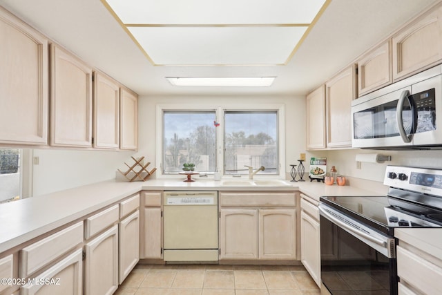 kitchen with light brown cabinets, appliances with stainless steel finishes, and a sink