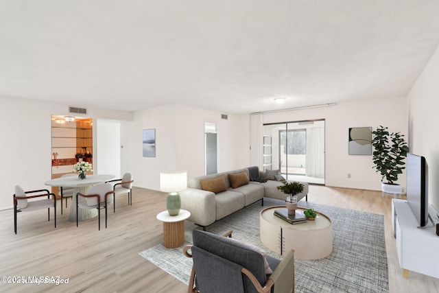 living area featuring light wood-type flooring and visible vents