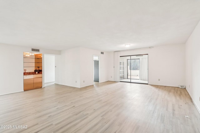 unfurnished living room with visible vents and light wood finished floors