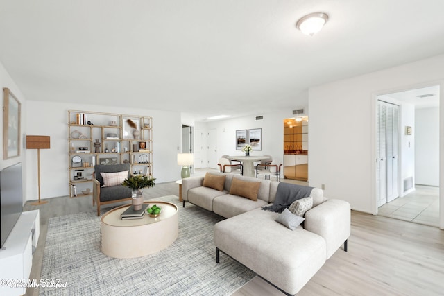 living area with visible vents and light wood-style floors