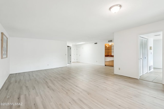 unfurnished living room with visible vents and light wood-type flooring