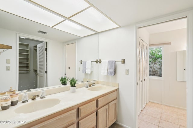 full bath featuring tile patterned flooring, double vanity, visible vents, and a sink