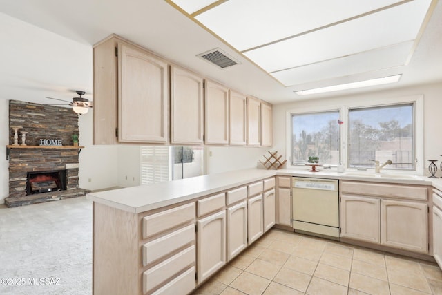 kitchen with visible vents, light brown cabinets, dishwasher, a peninsula, and a sink