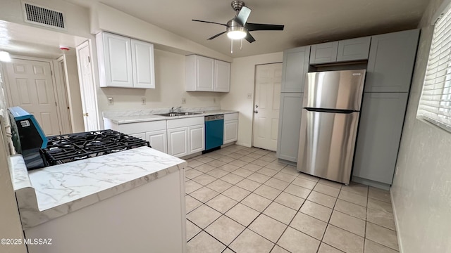 kitchen with sink, white cabinetry, light tile patterned floors, ceiling fan, and stainless steel appliances