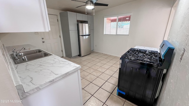 kitchen with sink, stainless steel fridge, ceiling fan, gas stove, and light tile patterned flooring