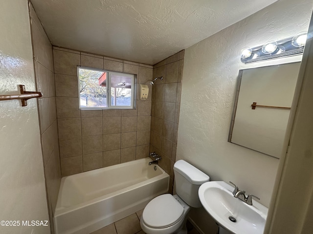 full bathroom featuring tiled shower / bath combo, sink, a textured ceiling, and toilet