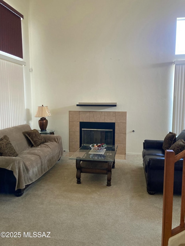 living room with a tile fireplace and light colored carpet