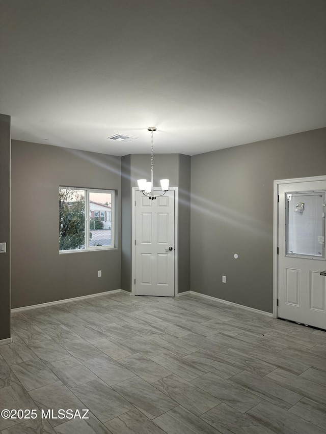 unfurnished dining area with a notable chandelier