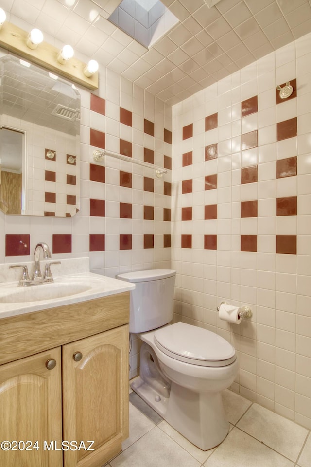 bathroom featuring tile walls, tile patterned flooring, and toilet