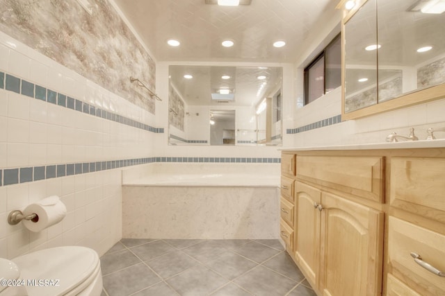 bathroom featuring tile patterned flooring, vanity, tile walls, and toilet