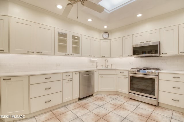 kitchen featuring sink, light tile patterned floors, ceiling fan, stainless steel appliances, and decorative backsplash