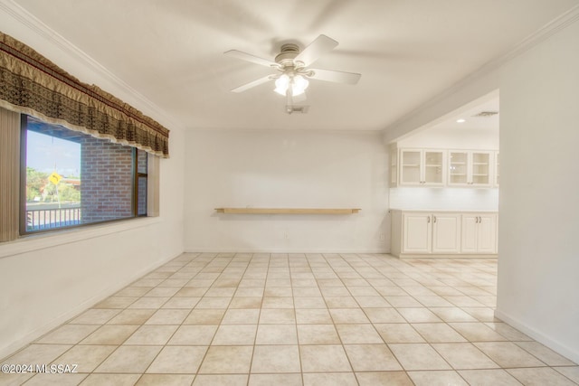 tiled spare room featuring ornamental molding and ceiling fan