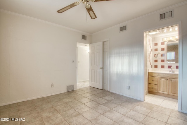 unfurnished bedroom with light tile patterned flooring, connected bathroom, sink, crown molding, and ceiling fan