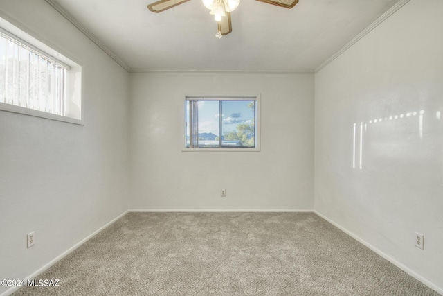 empty room featuring light carpet, crown molding, and ceiling fan