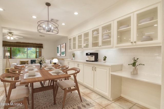 dining room featuring light tile patterned floors and ceiling fan with notable chandelier