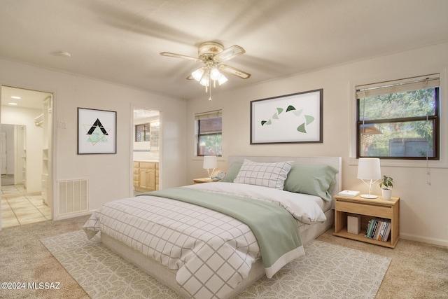 carpeted bedroom with ceiling fan and ensuite bath