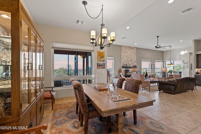 kitchen featuring light stone countertops, appliances with stainless steel finishes, a kitchen bar, wall chimney range hood, and a center island with sink