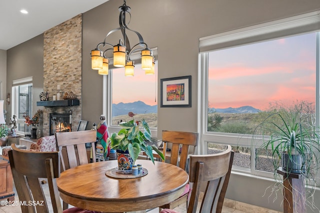 dining room with an inviting chandelier, a fireplace, a mountain view, and recessed lighting