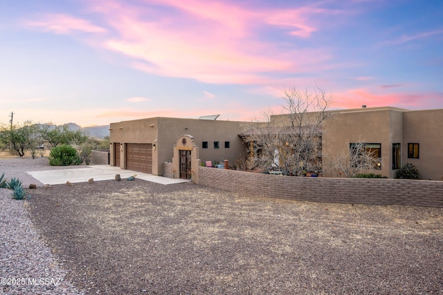 pueblo-style house featuring a garage