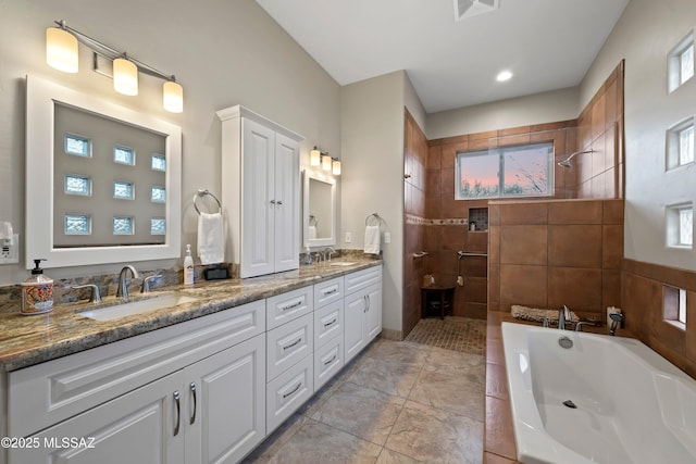 bathroom featuring a bath, double vanity, walk in shower, and a sink