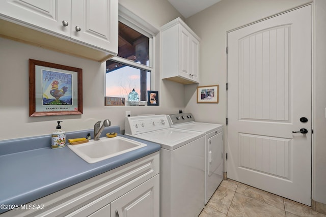 washroom featuring cabinet space, washer and dryer, and a sink