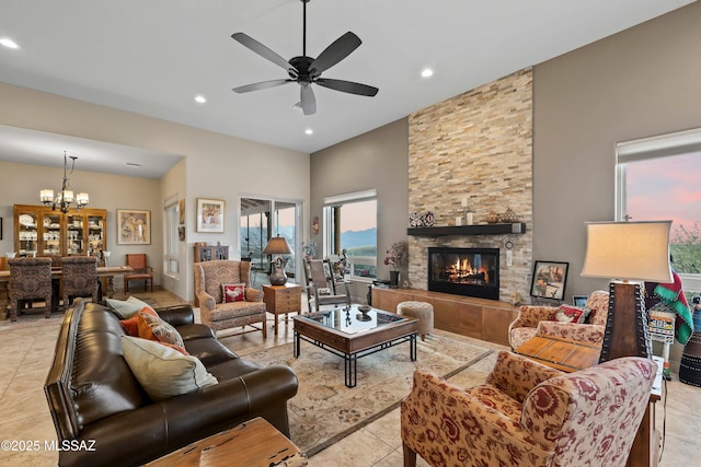 living room with light tile patterned floors, recessed lighting, ceiling fan with notable chandelier, and a stone fireplace