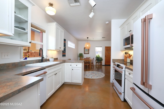 kitchen with white appliances, decorative light fixtures, white cabinetry, sink, and kitchen peninsula