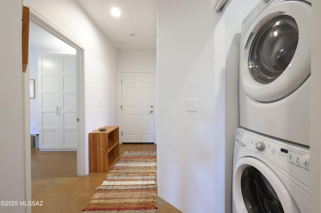 clothes washing area featuring stacked washer and dryer