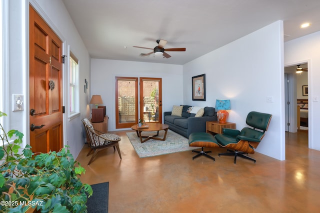 living room featuring ceiling fan and concrete floors