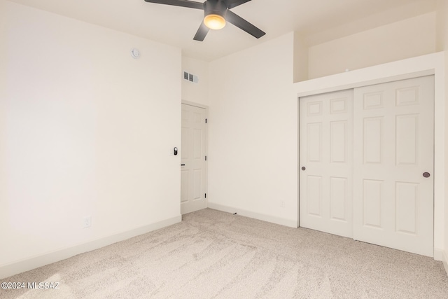 unfurnished bedroom with carpet flooring, ceiling fan, and a closet