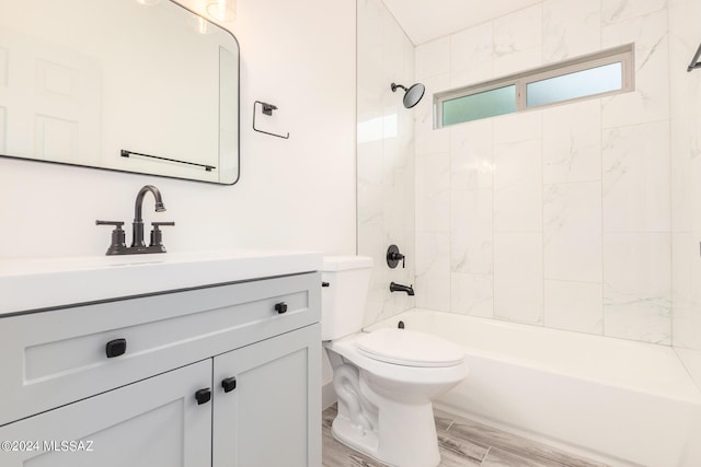 full bathroom featuring toilet, vanity, and tiled shower / bath