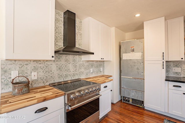 kitchen with white cabinetry, high end stainless steel range, and wall chimney exhaust hood