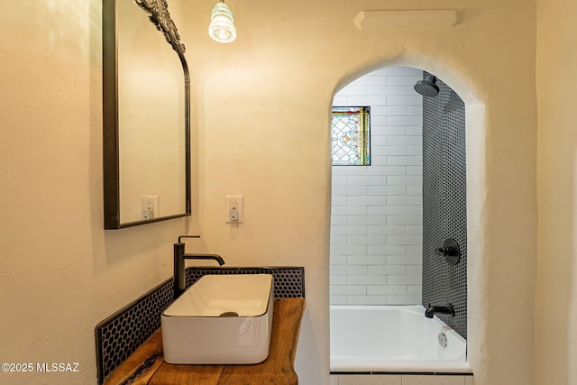 bathroom featuring tiled shower / bath combo and sink