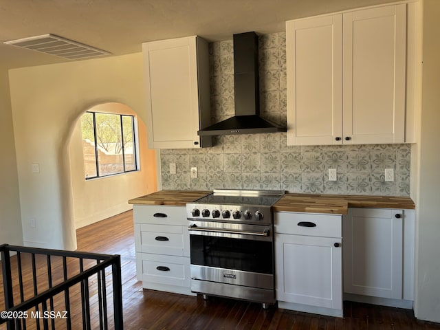 kitchen with wall chimney range hood, wooden counters, luxury range, white cabinets, and dark hardwood / wood-style flooring