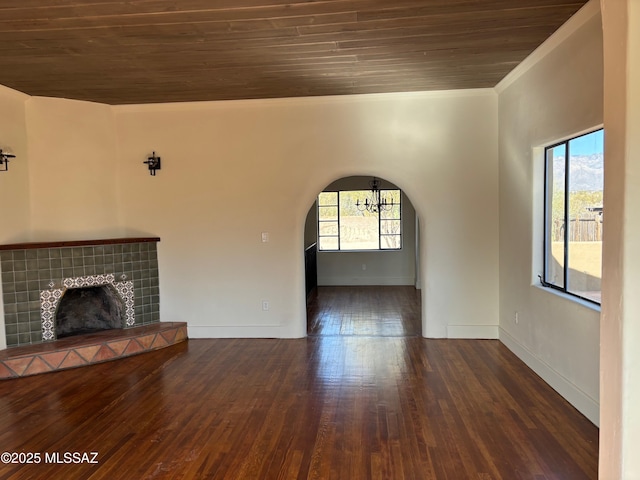 unfurnished living room with dark hardwood / wood-style floors, a healthy amount of sunlight, a fireplace, and crown molding