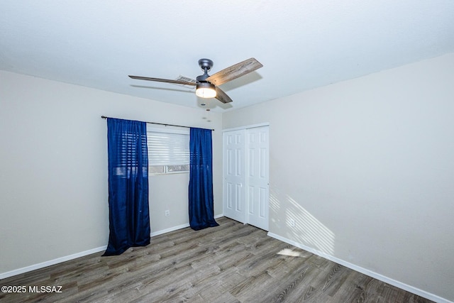 unfurnished bedroom featuring a closet, hardwood / wood-style flooring, and ceiling fan